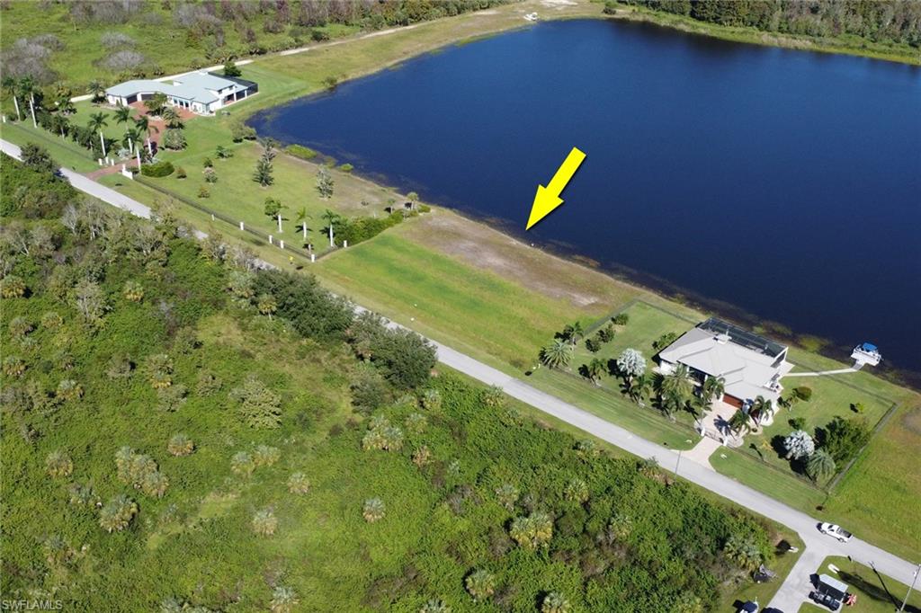 Aerial overview of property's location with a heavily wooded area and a nearby body of water