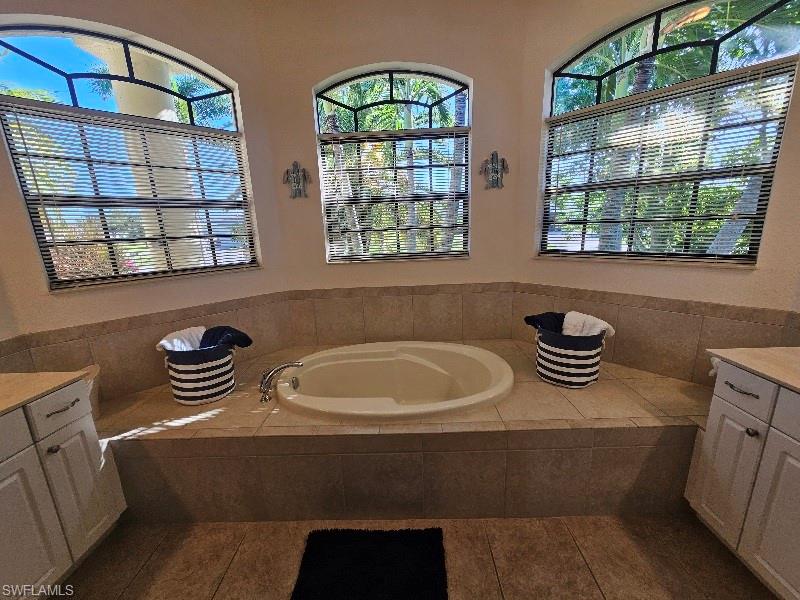 Full bath featuring a garden tub and vanity