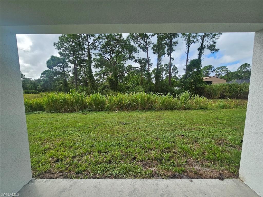 View of green lawn with view of wooded area
