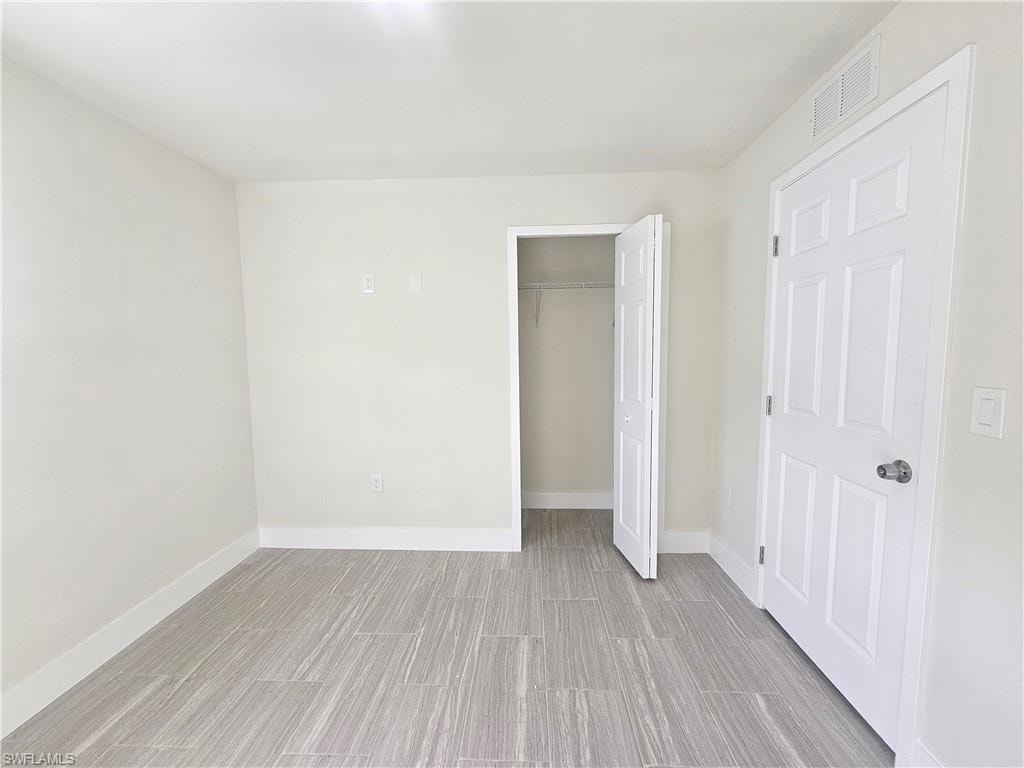 Unfurnished bedroom featuring wood finish floors and a closet