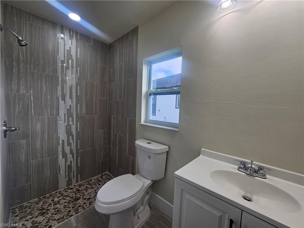 Full bath featuring vanity and a tile shower