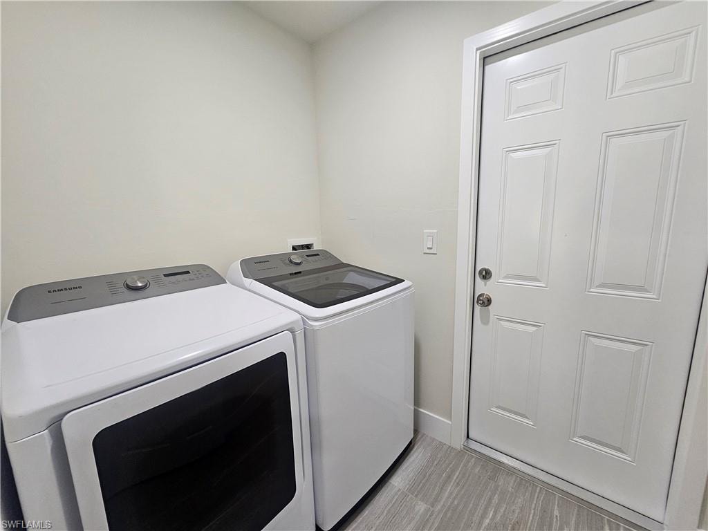 Laundry room with washer and dryer and baseboards