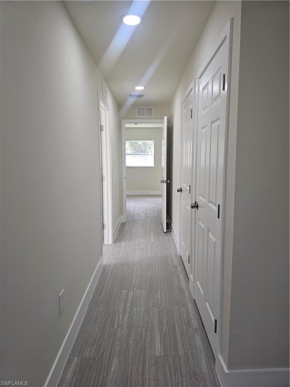 Hallway with baseboards and recessed lighting
