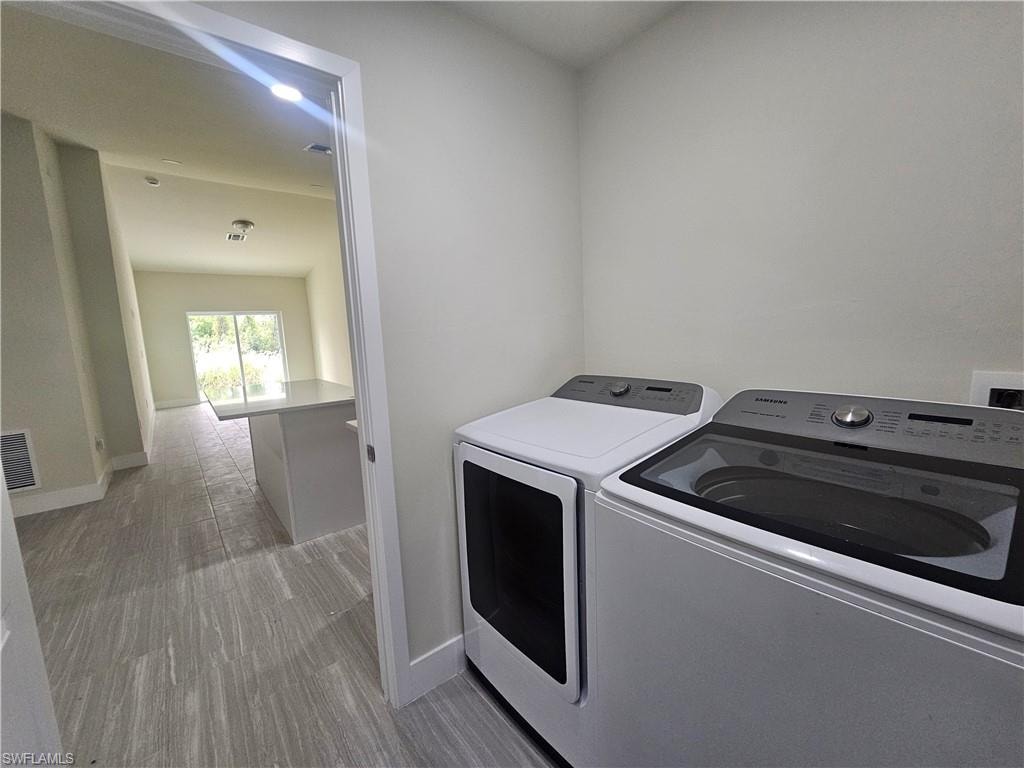 Laundry room featuring light wood-style floors and independent washer and dryer