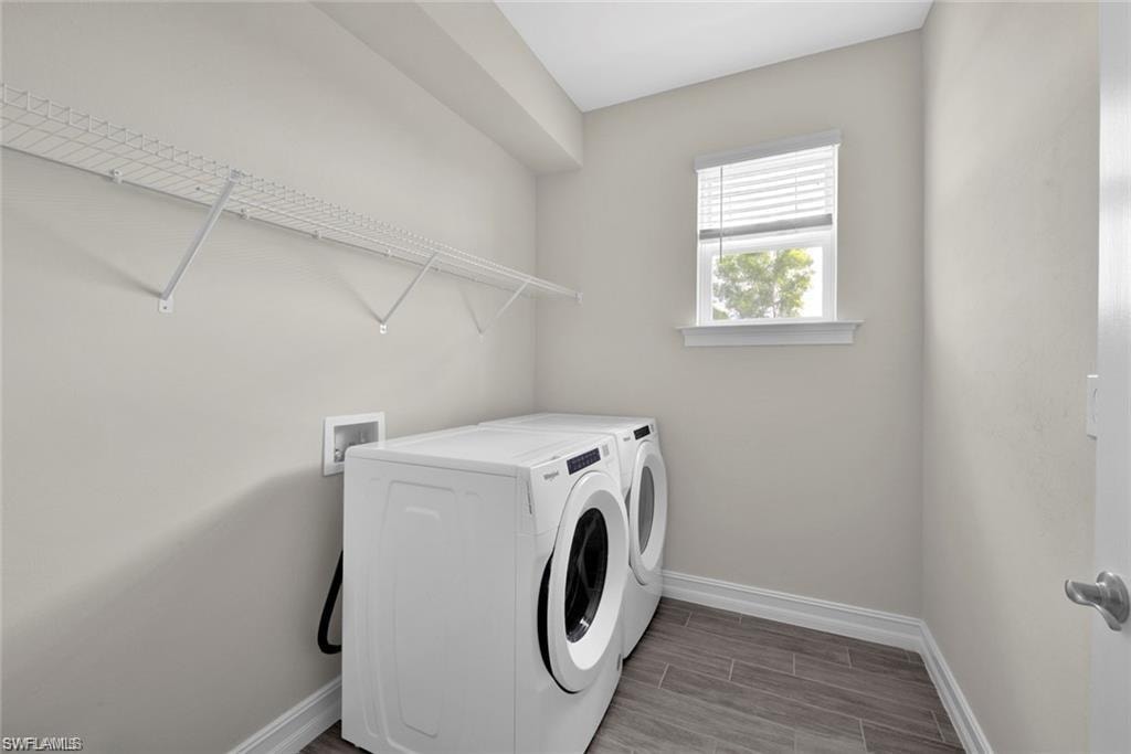 Laundry room with wood tiled floors and washer and clothes dryer