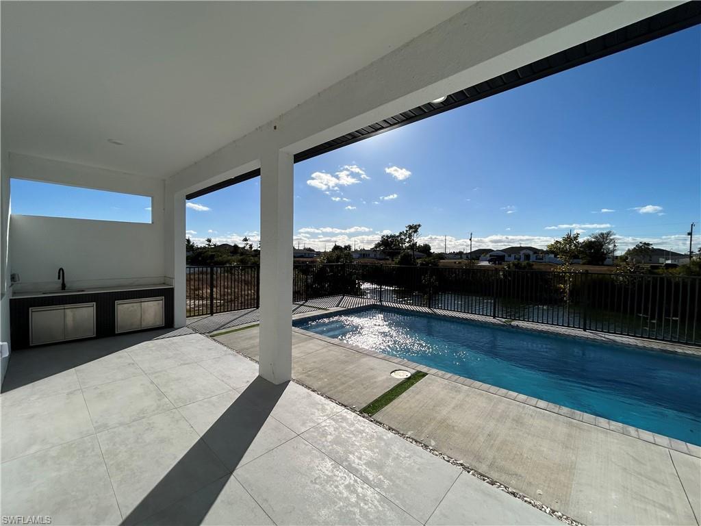 View of pool featuring a fenced backyard and area for grilling
