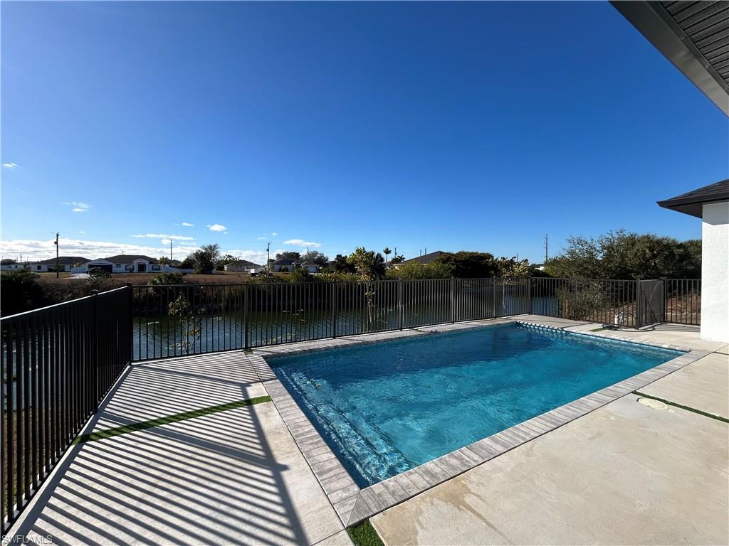 View of swimming pool featuring patio surround and a fenced backyard
