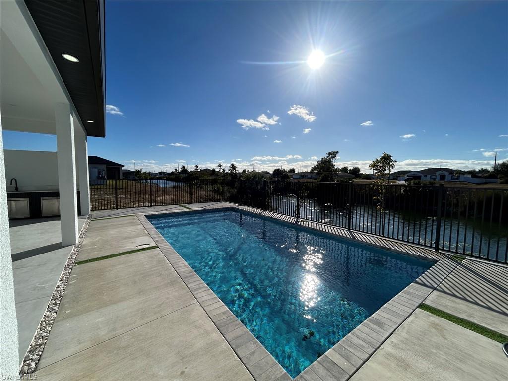 View of swimming pool featuring a fenced backyard and patio surround