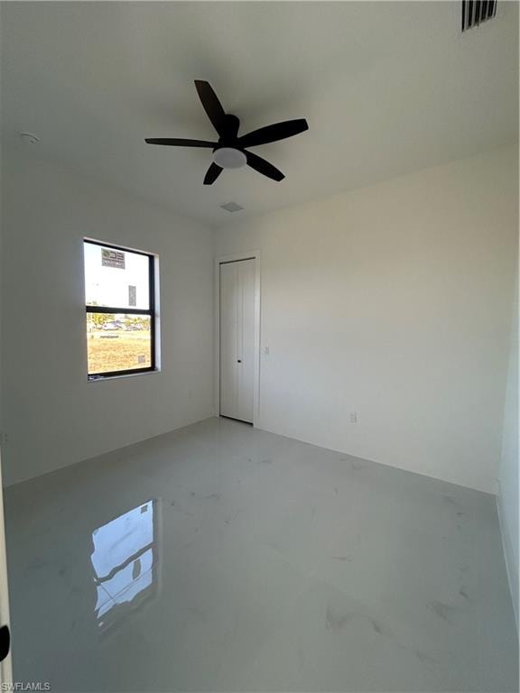 Empty room featuring concrete flooring and ceiling fan