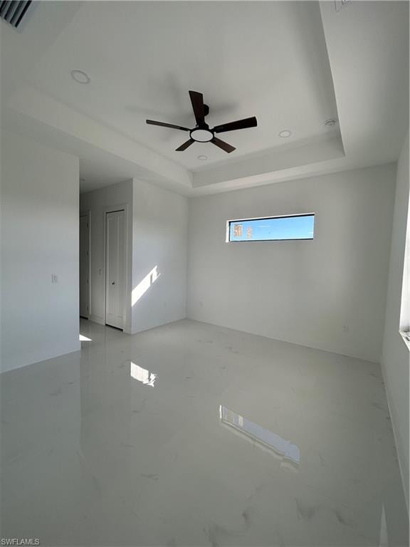 Spare room featuring ceiling fan, a tray ceiling, and recessed lighting
