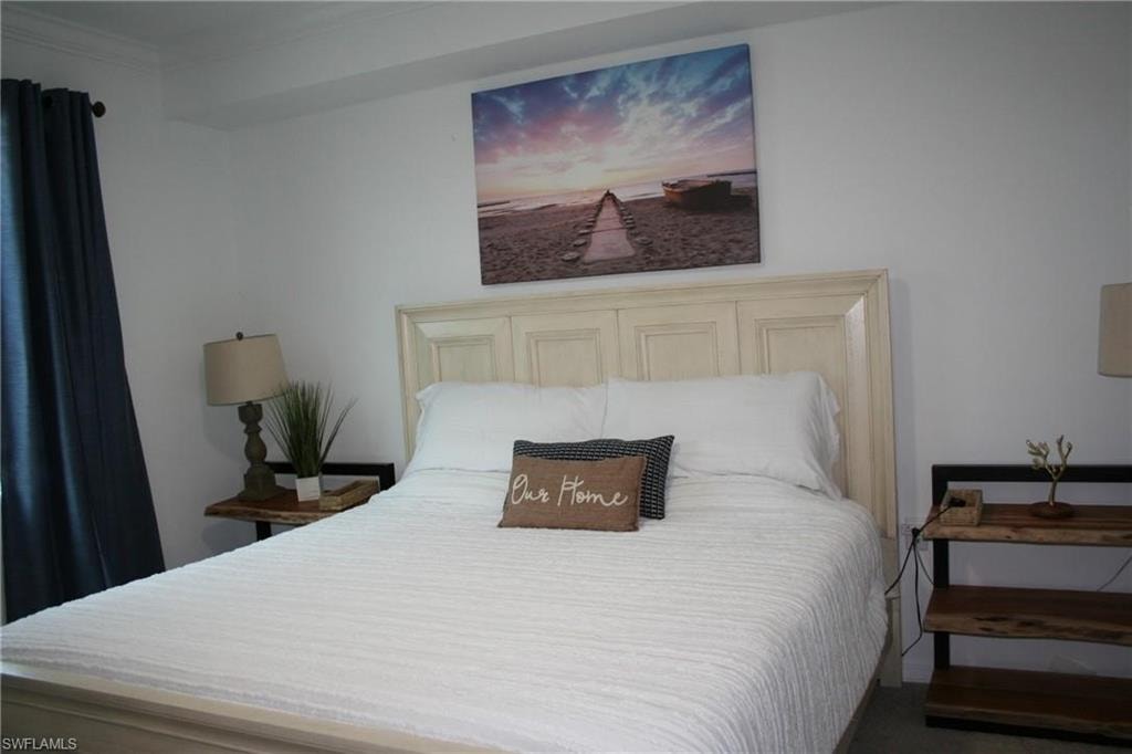 Carpeted bedroom with crown molding