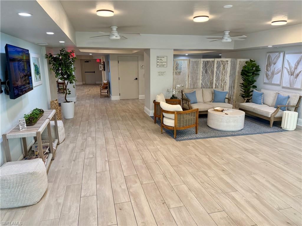 Spacious common area featuring wood-finish flooring throughout, a dedicated seating arrangement, recessed lighting, and ceiling fans