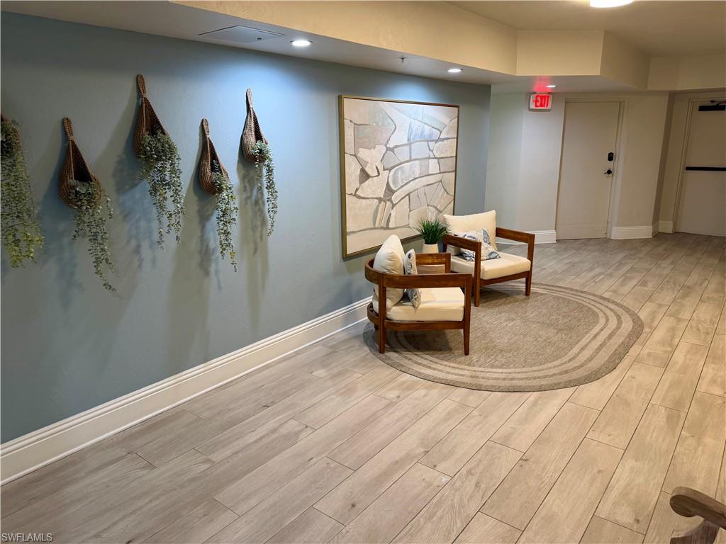 Spacious common area featuring wood-finish flooring throughout, a dedicated seating arrangement, recessed lighting