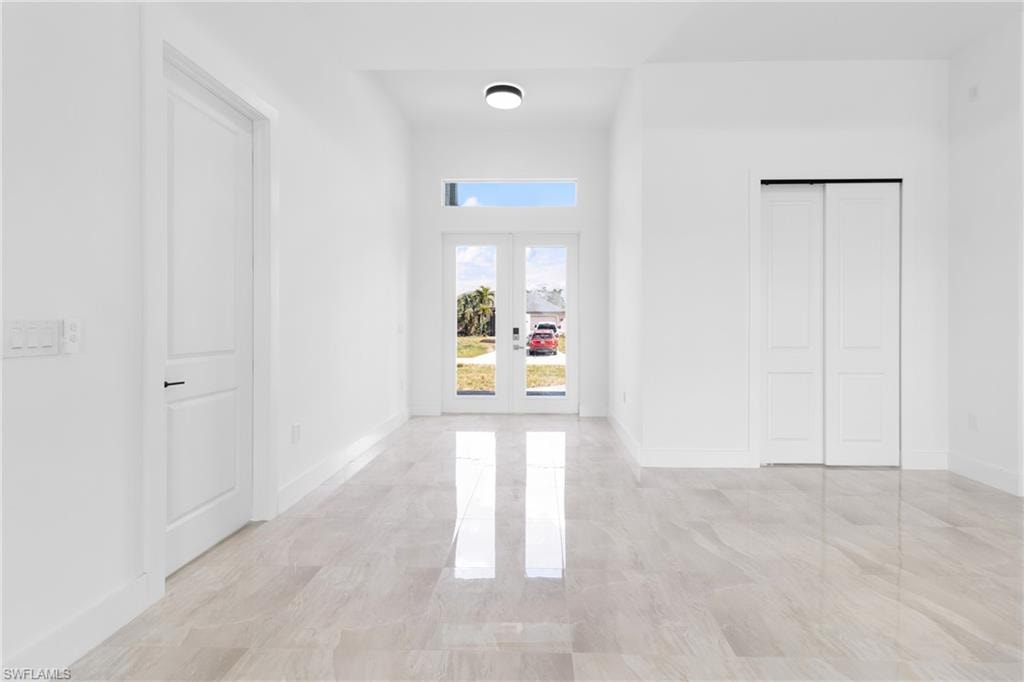 Corridor featuring french doors and baseboards