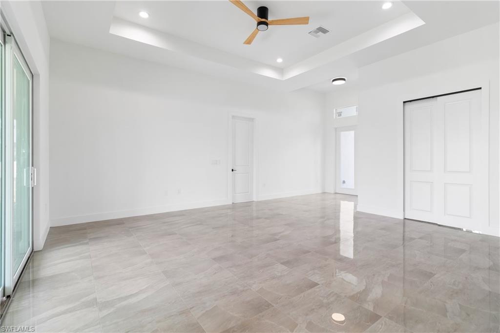 Unfurnished room featuring visible vents, baseboards, a raised ceiling, a ceiling fan, and recessed lighting