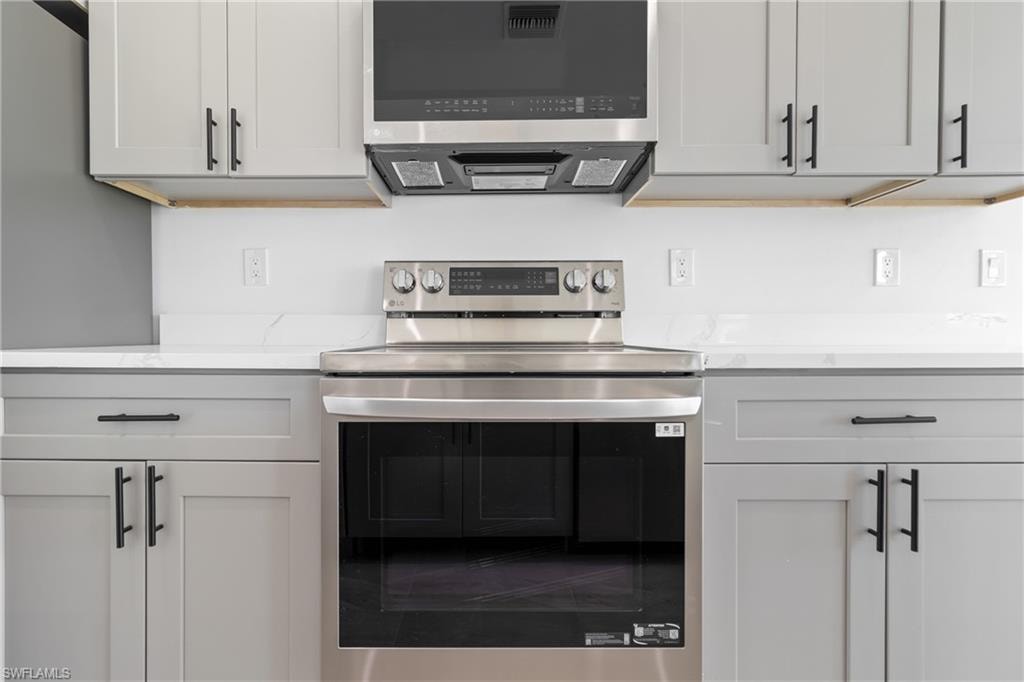 Kitchen with light stone counters and stainless steel appliances