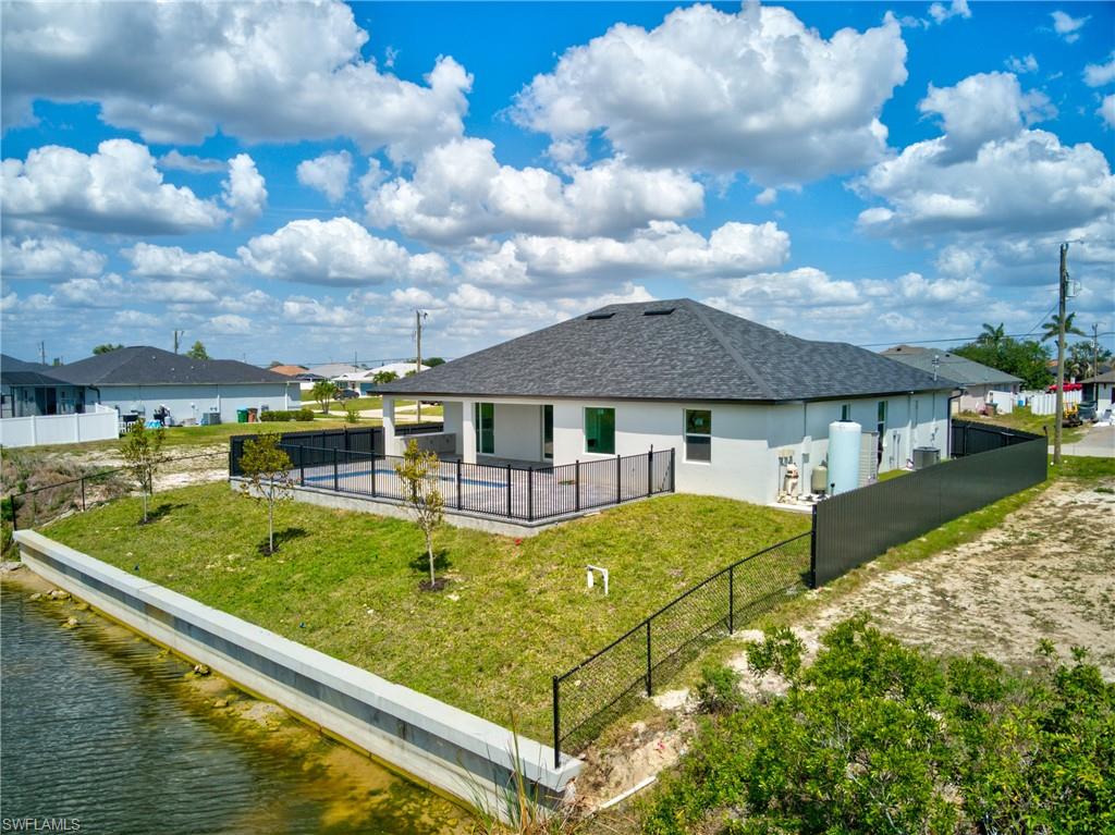 Back of property with a patio, fence, and a lawn