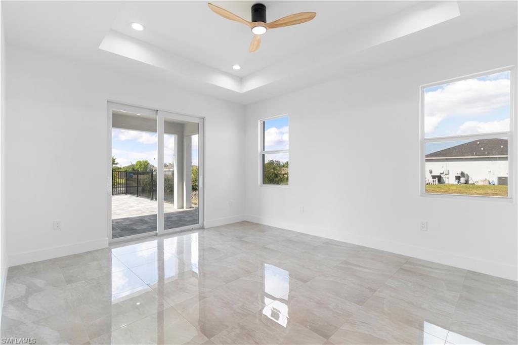 Unfurnished room with a raised ceiling, baseboards, a ceiling fan, and recessed lighting
