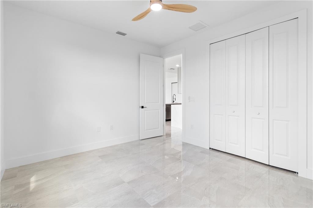 Unfurnished bedroom with a closet, baseboards, ceiling fan, and visible vents