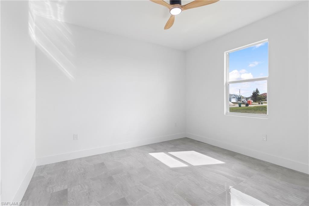 Spare room with baseboards and a ceiling fan