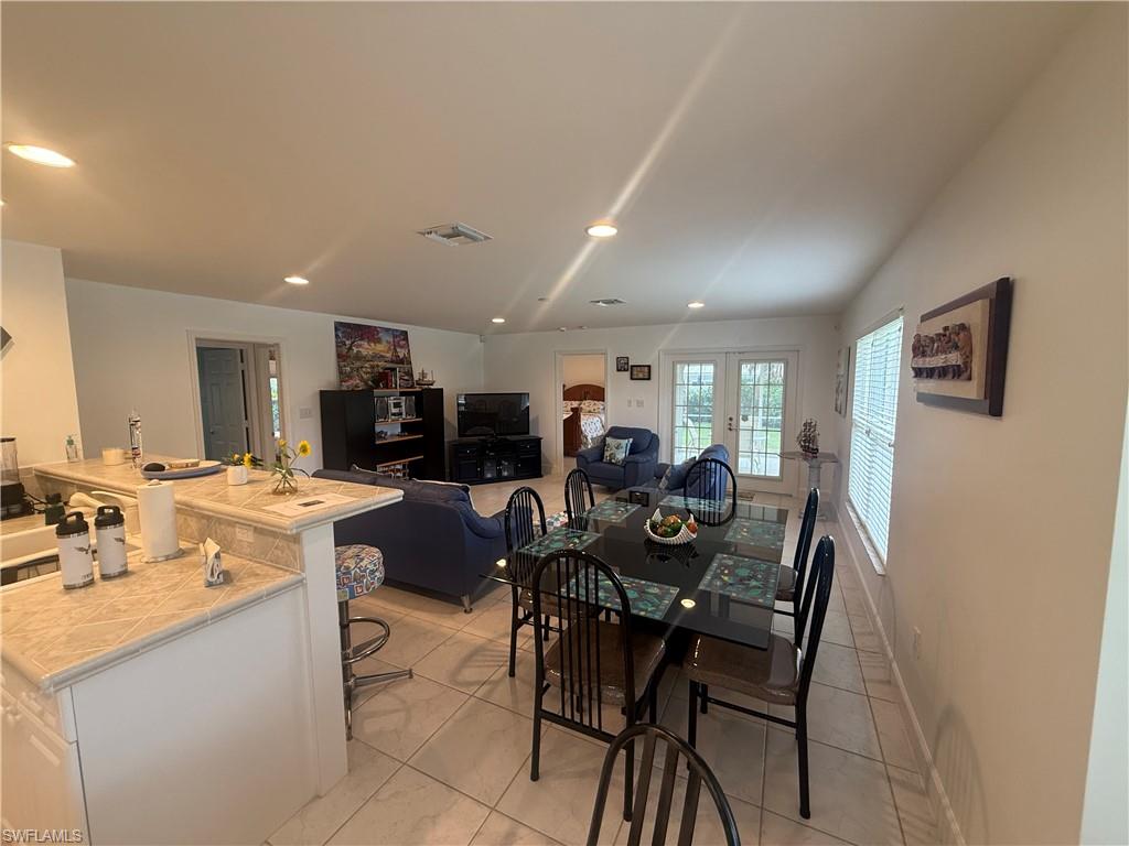 Dining room featuring french doors, light tile patterned floors, and recessed lighting