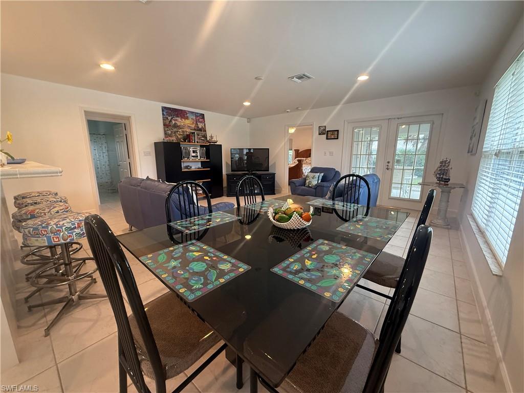 Kitchen with a kitchen breakfast bar, light countertops, white cabinetry, recessed lighting, and a peninsula