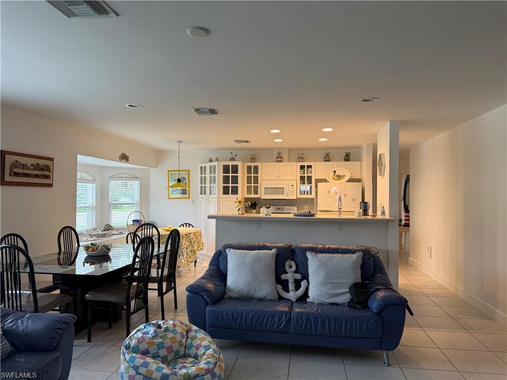 Living area with light tile patterned floors and a chandelier