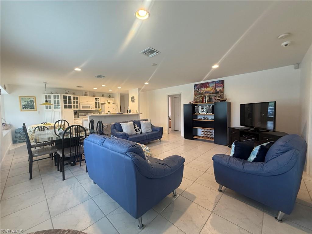 Living area with light tile patterned flooring and recessed lighting