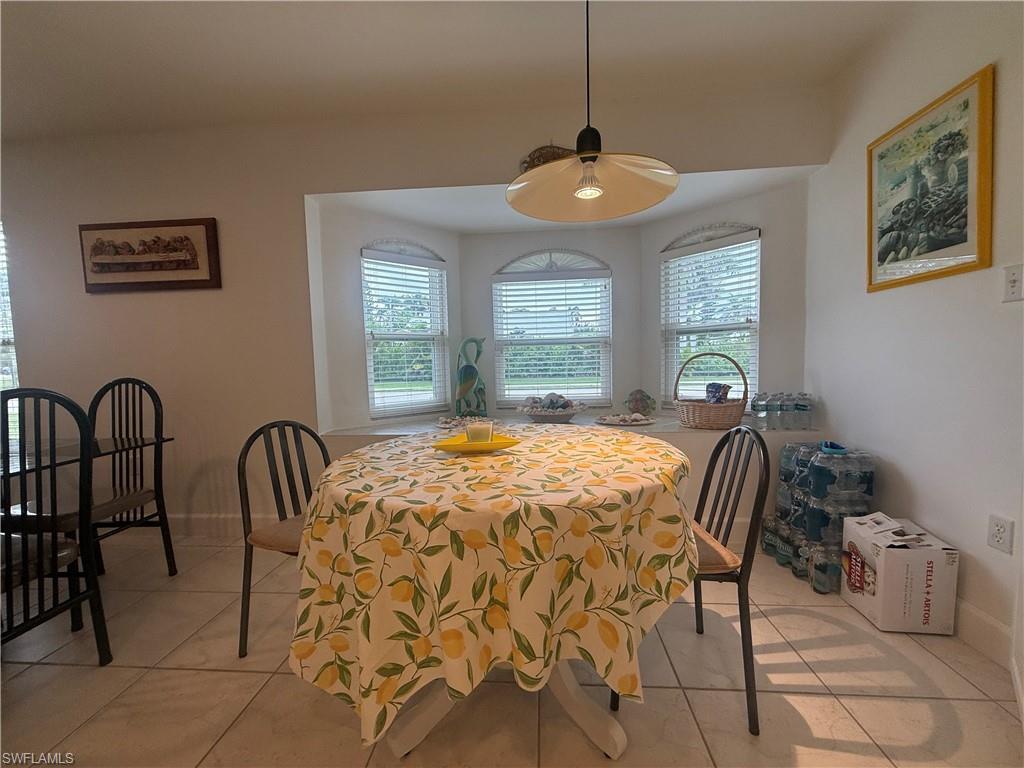 Kitchen with white cabinetry, recessed lighting, hanging light fixtures, and light tile patterned floors