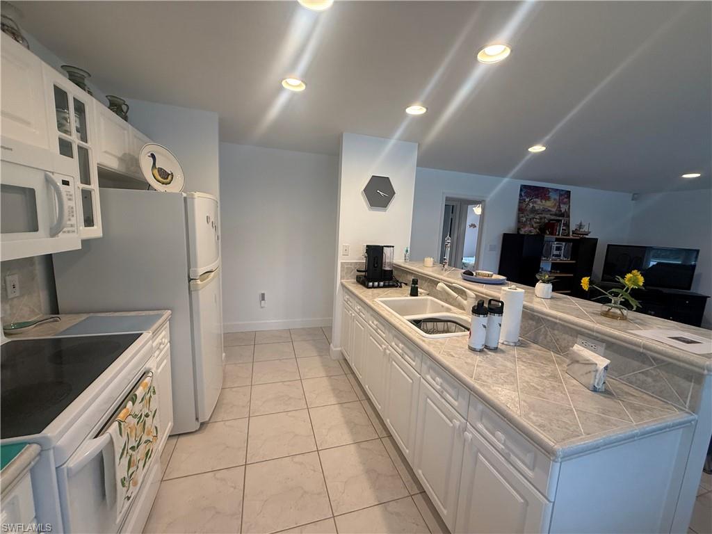 Living area featuring tile patterned floors and a chandelier
