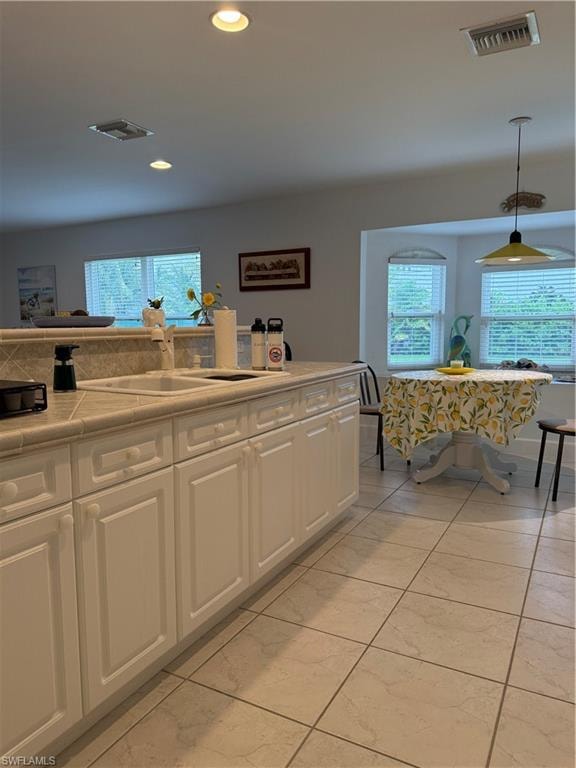 Kitchen with white appliances, recessed lighting, a breakfast bar, white cabinets, and a peninsula
