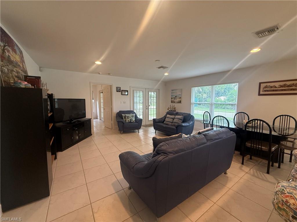 Living room with tile patterned floors and a chandelier