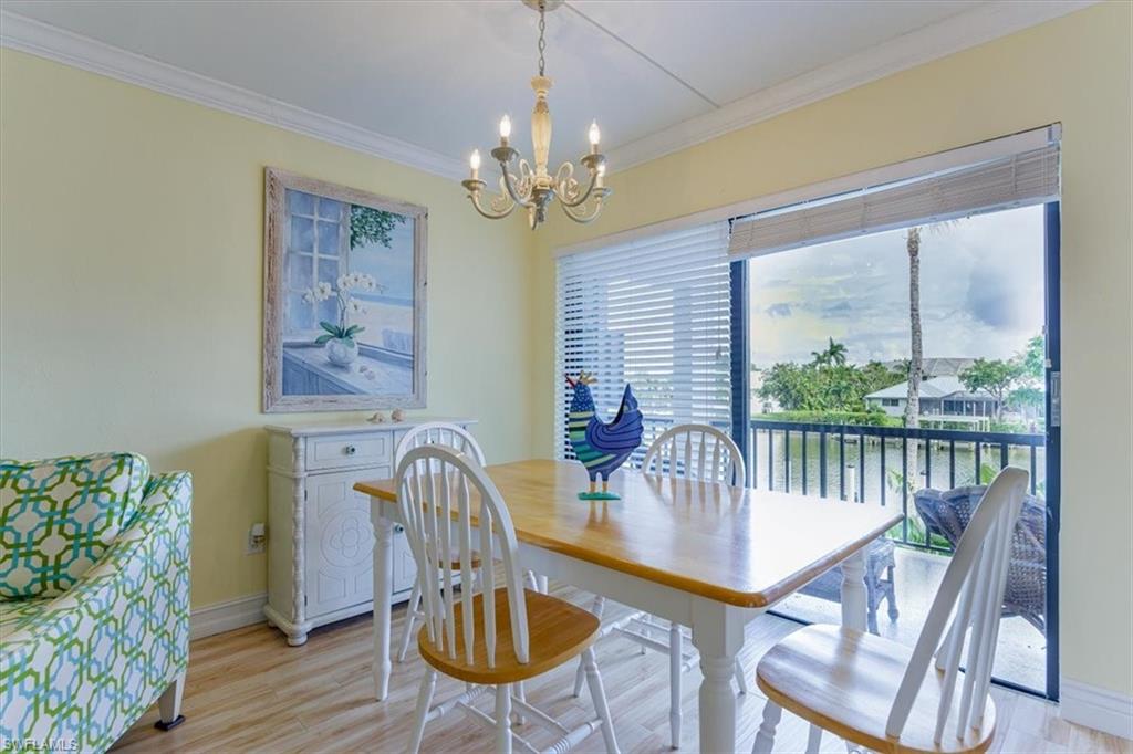 Dining room featuring crown molding, light wood-style floors, and a chandelier