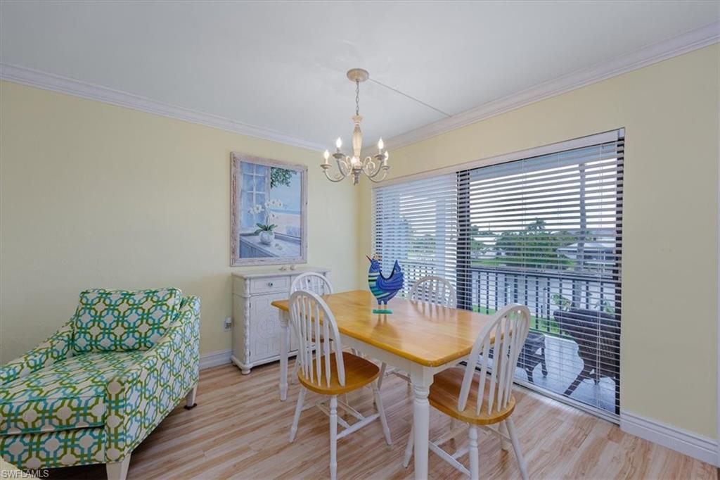 Dining space featuring ornamental molding, wood finished floors, and a chandelier