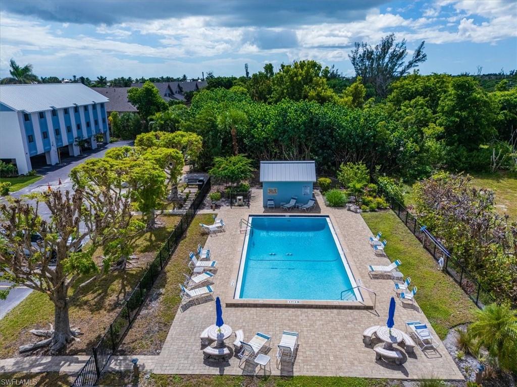 Community pool with a patio area, a fenced backyard, and a fire pit