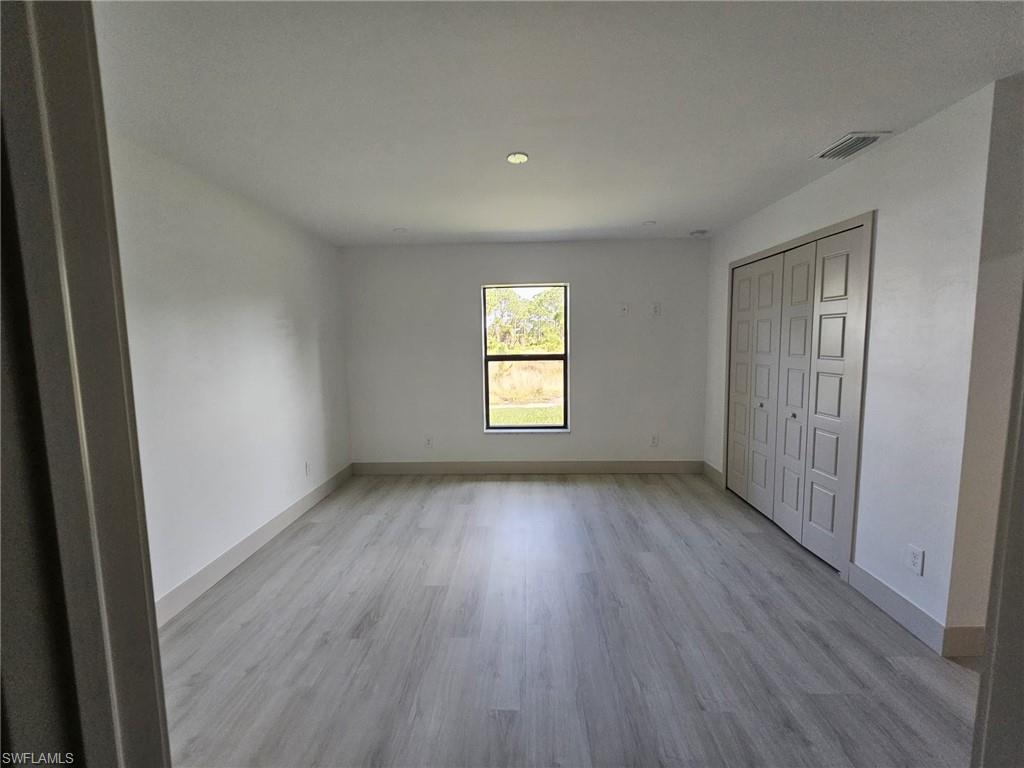 Unfurnished bedroom featuring light wood-style floors and a closet