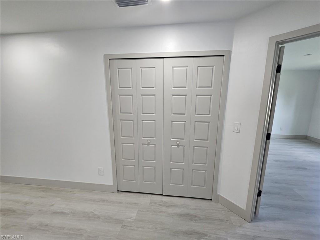 Unfurnished bedroom featuring a closet and light wood-type flooring