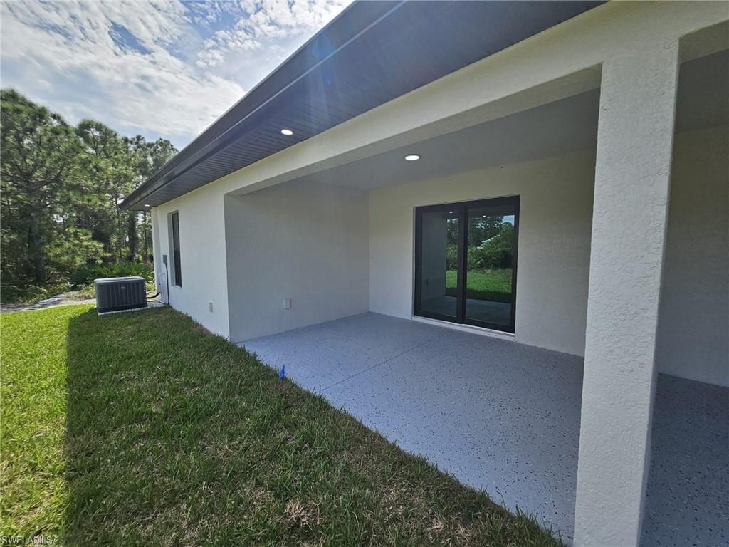Rear view of property featuring a patio, stucco siding, and a yard