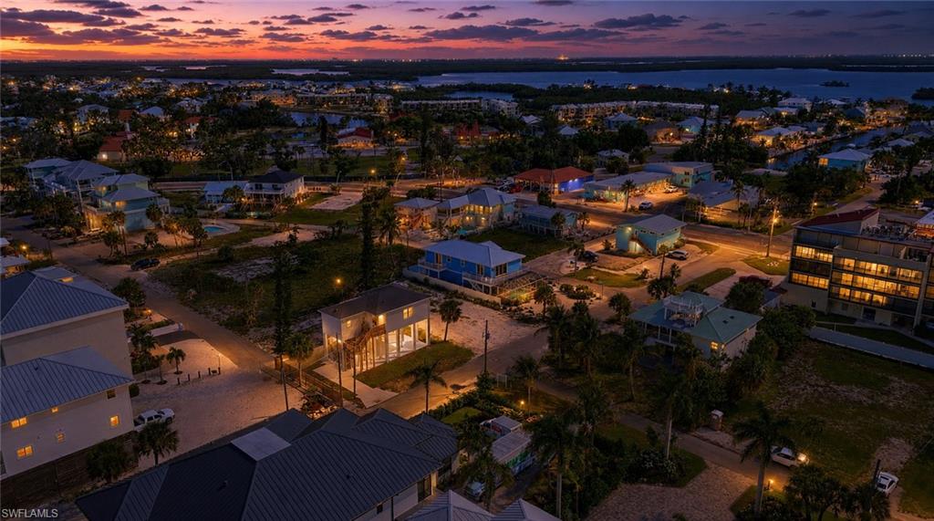 Coastal community featuring residential properties, street lighting, and visible waterways. virtually enhanced.