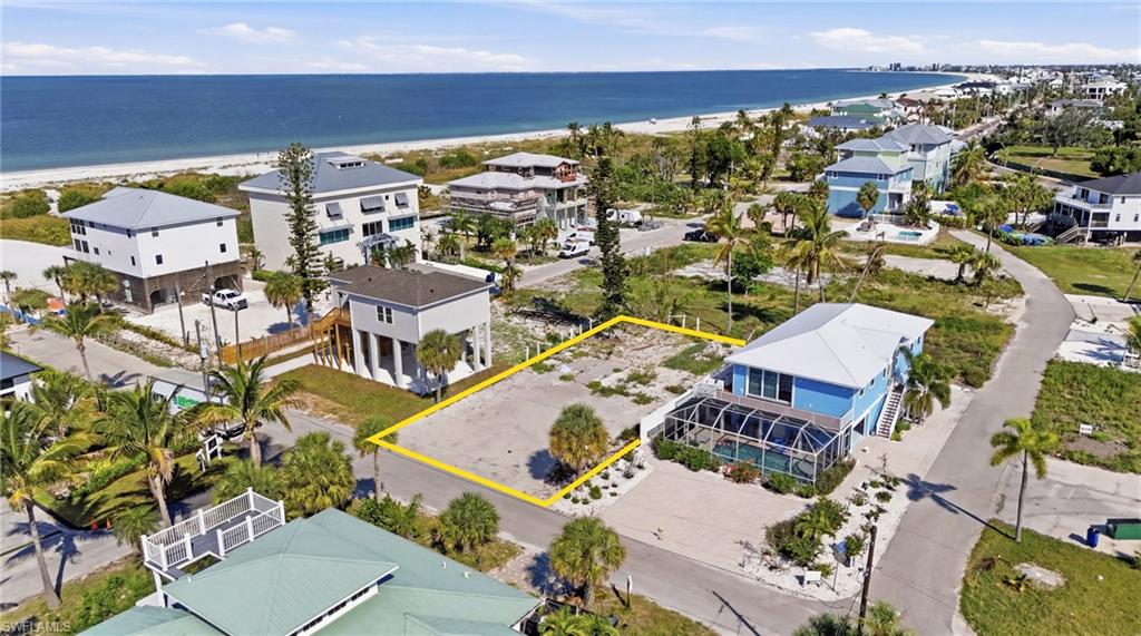 Cleared residential lot situated on a paved road, featuring a level topography and scattered native landscaping. virtually enhanced