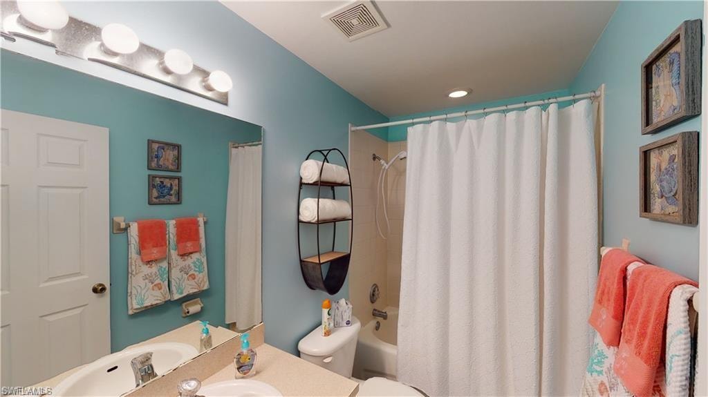 Bathroom featuring shower / bath combo with shower curtain and vanity