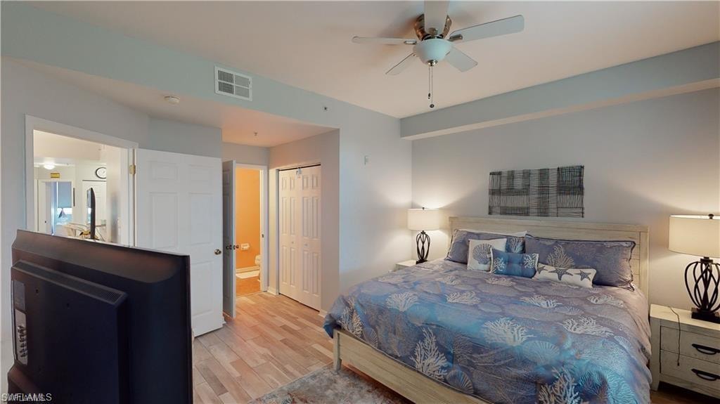 Bedroom with wood finished floors, a closet, ceiling fan, and ensuite bath