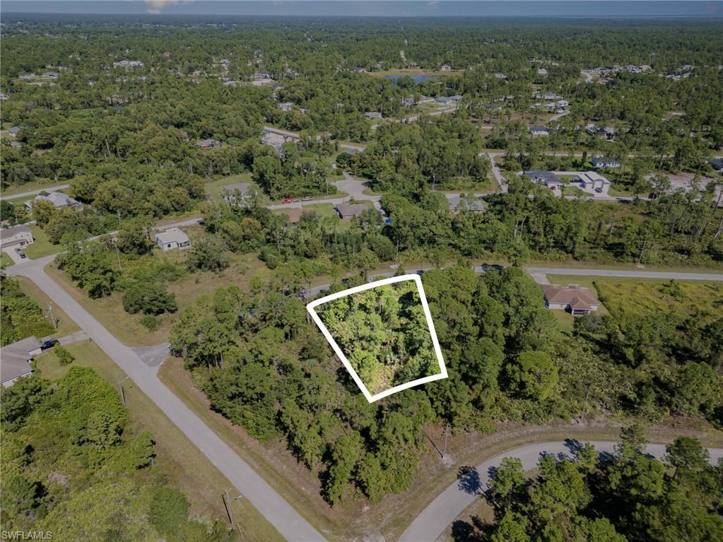 Aerial view of property's location featuring property parcel outlined and a forest