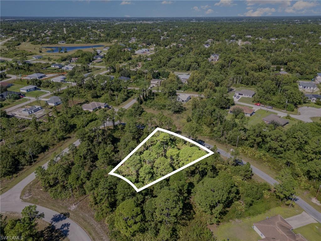 Aerial view of property and surrounding area with property parcel outlined and a large body of water