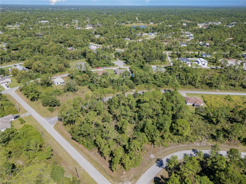 Aerial view of property and surrounding area featuring a forest