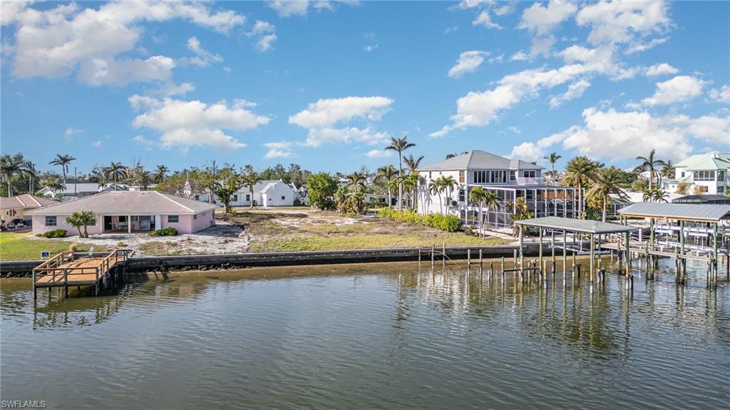 Dock area featuring a residential view, boat house, and water view