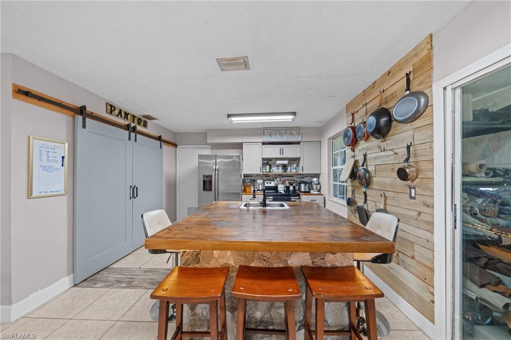 Dining room with a barn door and light tile patterned floors