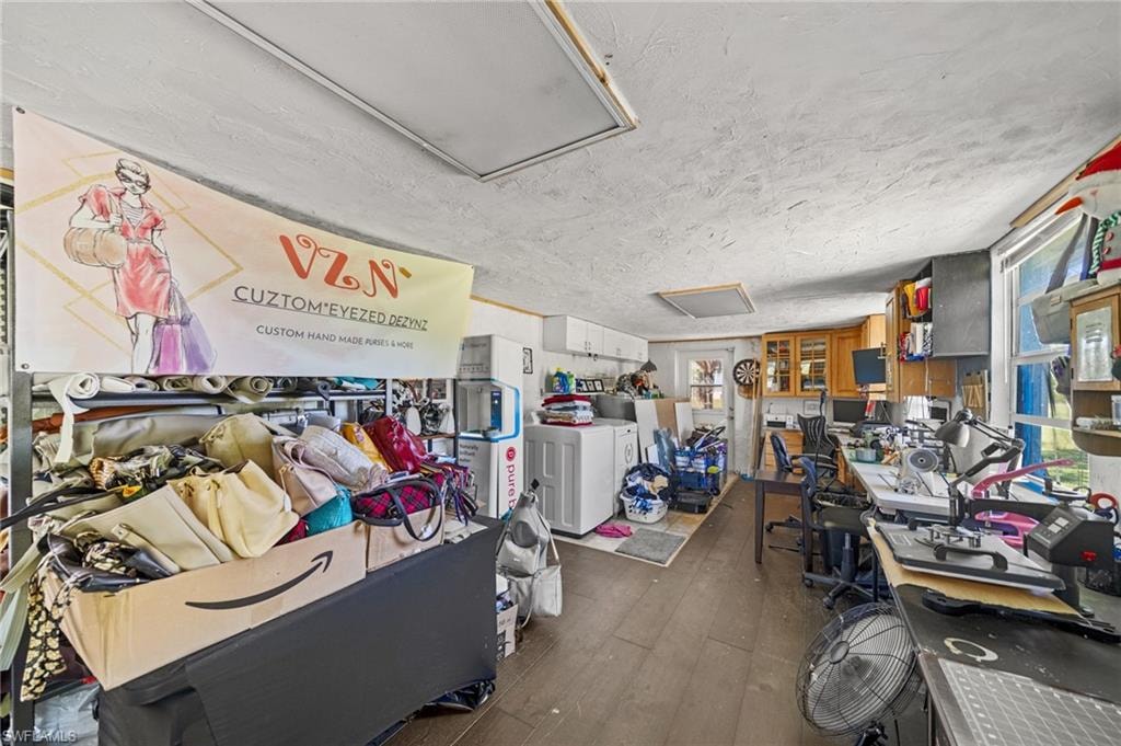 Miscellaneous room featuring dark wood-style floors, a textured ceiling, and washer and dryer