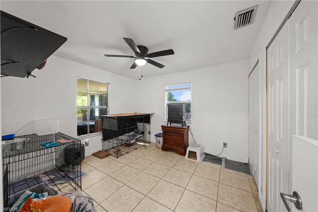 Office space with light tile patterned floors and ceiling fan