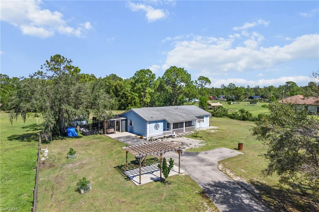 Aerial view of property and surrounding area with a tree filled landscape